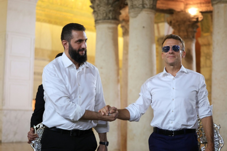 Le président français Emmanuel Macron (à droite) serre la main du président syrien Ahmad al-Chareh lors d'une visite à la mosquée des Omeyyades, à Damas, le 6 juillet 2026.