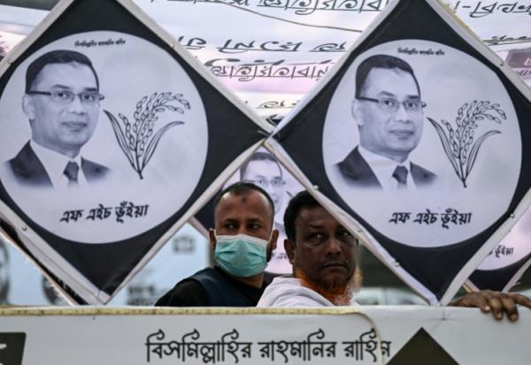 Des partisans du Parti nationaliste du Bangladesh (BNP) derrière des affiches du président du BNP et candidat aux élections, Tarique Rahman, lors d'un rassemblement au dernier jour de la campagne électorale, le 9 février 2026 à Dacca, au Bengladesh