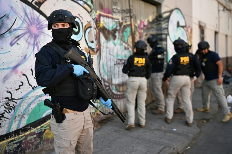 Des policiers pénètrent dans une habitation lors d'une opération antidrogue   à Santiago, le 11 décembre 2025 