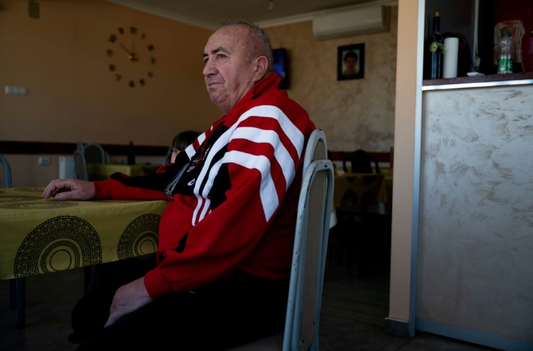 Jovan Zivic est assis dans le petit café qu'il tient dans le village de Plemetina, près d'une centrale thermique au charbon, le 8 avril 2026 au Kosovo