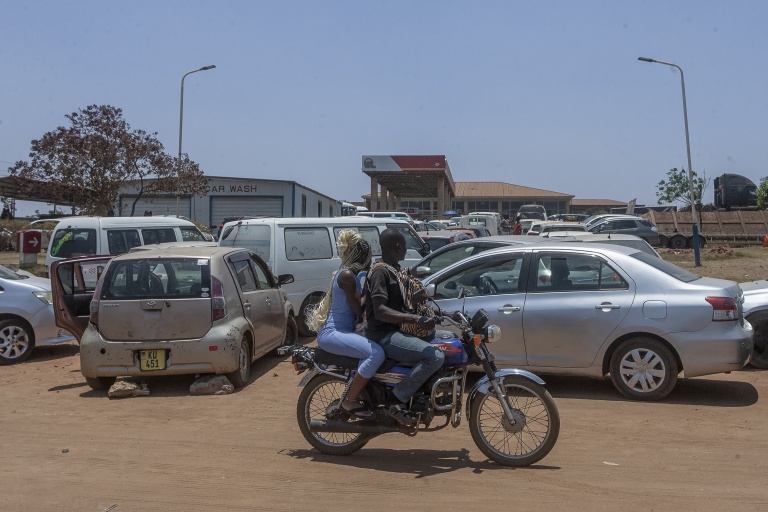 Des motocyclistes passent devant des véhicules faisant la queue pour du carburant à la station-service Best Oil, dans la zone 49 à Lilongwe, la capitale du Malawi, le 22 octobre 2026