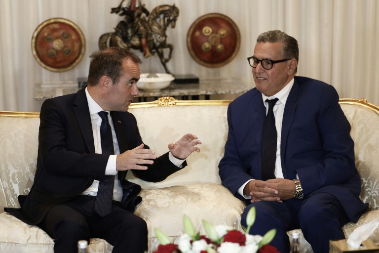 Le Premier ministre français Sébastien Lecornu (g) s'entretient avec le Premier ministre marocain Aziz Akhannouch à son arrivée à l'aéroport de Rabat-Salé, le 15 juillet 2026 à Rabat, au Maroc
