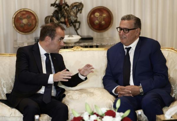 Le Premier ministre français Sébastien Lecornu (g) s'entretient avec le Premier ministre marocain Aziz Akhannouch à son arrivée à l'aéroport de Rabat-Salé, le 15 juillet 2026 à Rabat, au Maroc