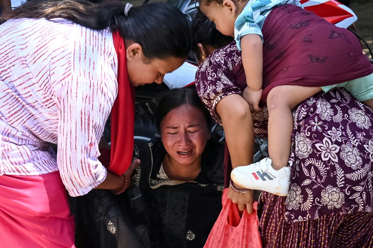 Une femme s’effondre tandis qu’elle attend l’arrivée de ses proches dans un camp militaire après avoir été secourue des zones touchées par des crues subites, dans la ville de Battar Bazar, dans le district de Nuwakot au Népal, le 27 août 2026