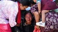 Une femme s’effondre tandis qu’elle attend l’arrivée de ses proches dans un camp militaire après avoir été secourue des zones touchées par des crues subites, dans la ville de Battar Bazar, dans le district de Nuwakot au Népal, le 27 août 2026