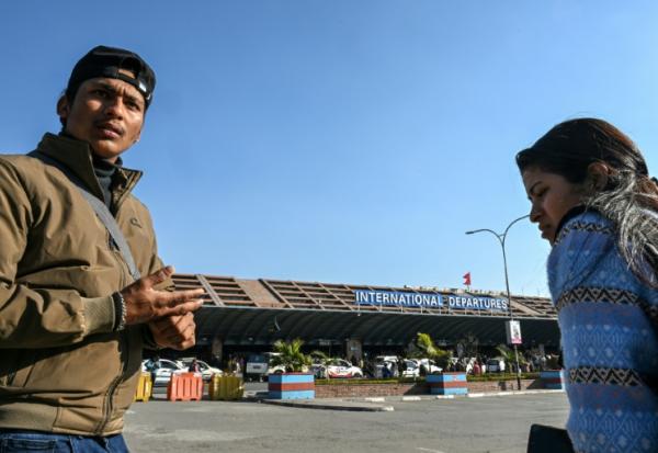 Lalit Bishowkarma (g) attend à l'aéroport international de Katmandou de récupérer la dépouille de son père Rudra Bahadur Kami, mort en Arabie saoudite où il était parti travailler, le 21 janvier 2026 au Népal