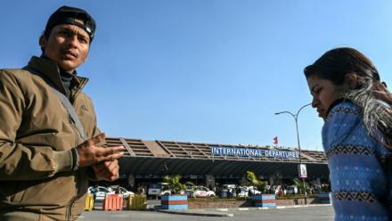 Lalit Bishowkarma (g) attend à l'aéroport international de Katmandou de récupérer la dépouille de son père Rudra Bahadur Kami, mort en Arabie saoudite où il était parti travailler, le 21 janvier 2026 au Népal