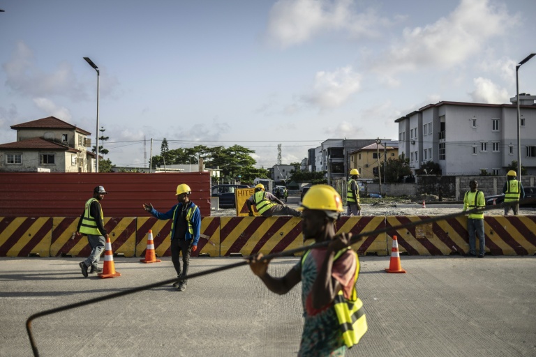 Un ouvrier du bâtiment transporte des matériaux sur un tronçon de l'autoroute côtière Lagos-Calabar, en cours de construction à Lagos, le 17 avril 2026.
