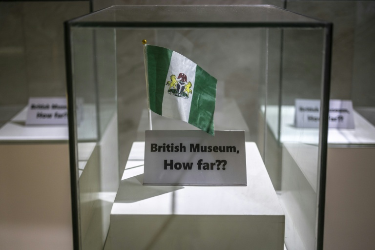 Un drapeau nigérian est exposé sous une vitrine, à côté d'une pancarte sur laquelle on peut lire 
