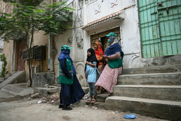 Des agentes de santé parlent à des adolescentes, lors d'une campagne de vaccination porte-à-porte contre le virus du papillome humain (VPH) responsable du cancer du col de l'utérus, le 24 septembre 2025 à Karachi, au Pakistan