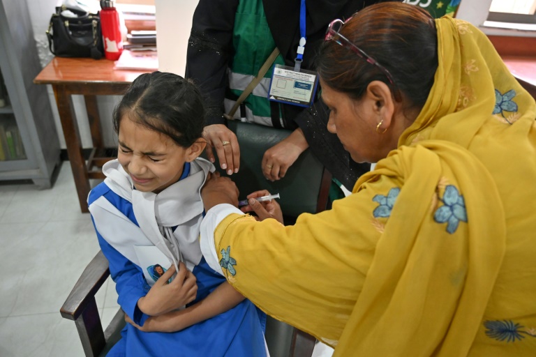 Une soignante (g) administre le vaccin contre le virus du papillome humain (VPH) à une adolescente, lors d'une campagne de vaccination contre le cancer du col de l'utérus, le 24 septembre 2025 à Karachi, au Pakistan