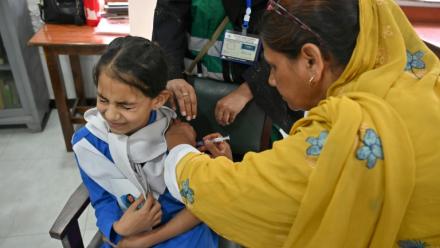 Une soignante (g) administre le vaccin contre le virus du papillome humain (VPH) à une adolescente, lors d'une campagne de vaccination contre le cancer du col de l'utérus, le 24 septembre 2025 à Karachi, au Pakistan