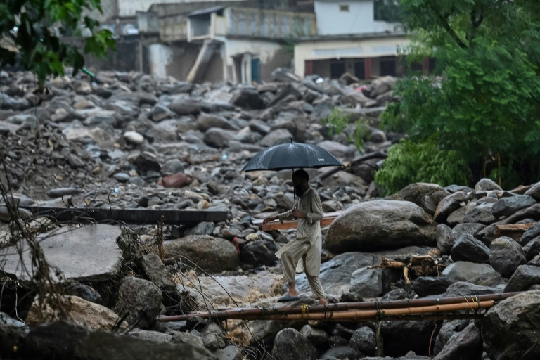 Un villageois traverse un pont de fortune sur le site d'une crue soudaine dans le district de Buner, dans la province de Khyber Pakhtunkhwa, le 18 août 2025 au Pakistan