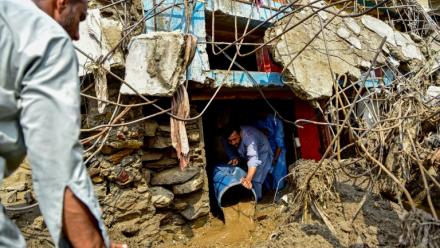 Un homme retire la boue de l'intérieur d'une maison suite aux crues subites dans la province montagneuse de Khyber Pakhtunkhwa au Pakistan le 16 août 2025