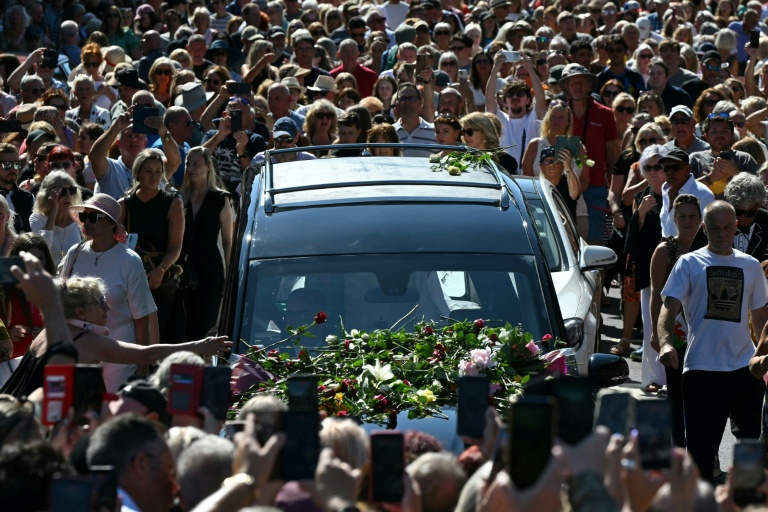 Des fans endeuillés se pressent le long des rues pour rendre hommage à la chanteuse Bonnie Tyler, dont le corbillard, transportant son cercueil, traverse sa ville natale de Mumbles, dans le sud-ouest du Pays de Galles, le 15 août 2026.