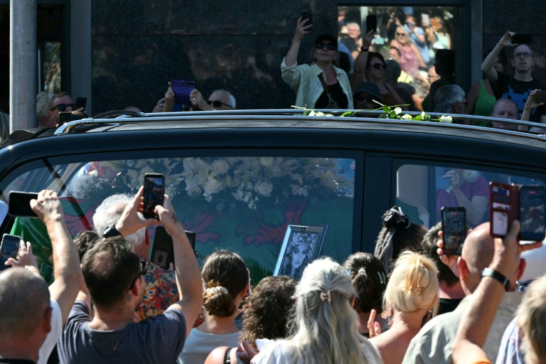 Des fans se pressent le long des rues pour rendre hommage à la chanteuse Bonnie Tyler, dont le corbillard transportant le cercueil traverse sa ville natale de Mumbles, dans le sud-ouest du Pays de Galles, le 15 août 2026.