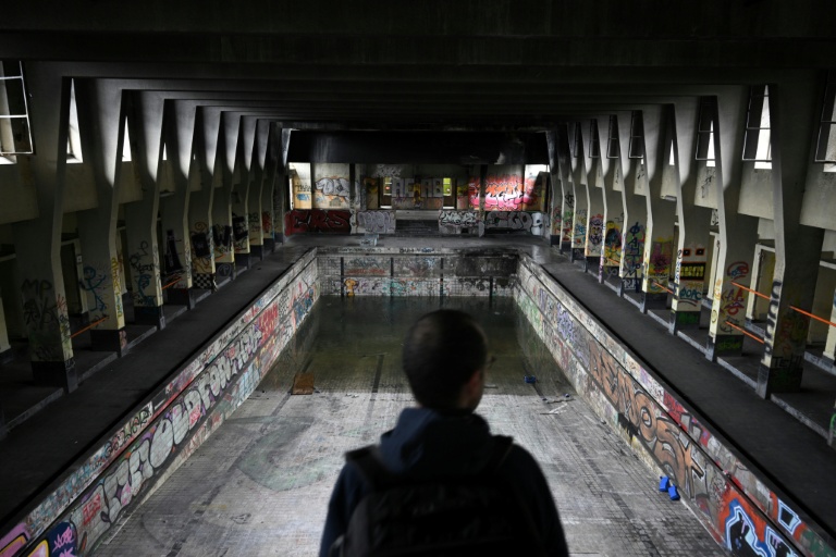 Un explorateur urbain (urbex) devant une ancienne piscine à l'abandon à Charleroi, dans le sud de la Belgique, le 11 mars 2026