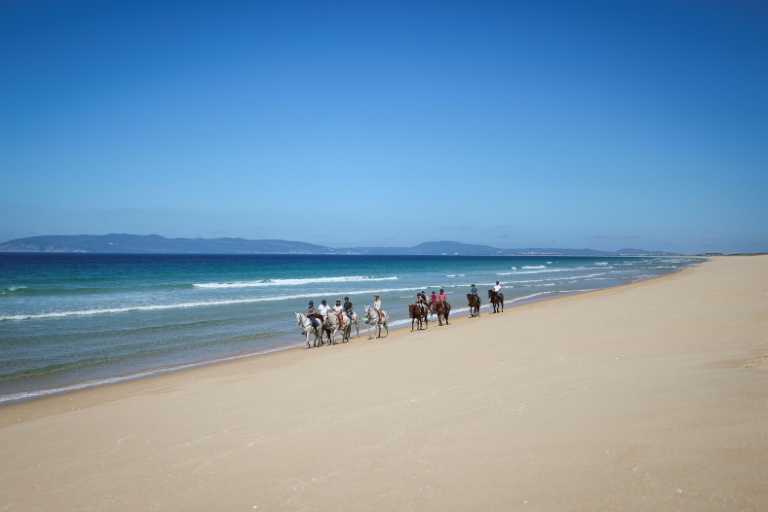 Des touristes se promènent à cheval sur la plage de Comporta, le 11 septembre 2025 au Portugal