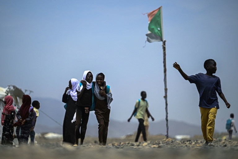 Des élèves sortent de l'école d'un camp de personnes déplacées par la guerre  près de Port-Soudan, le 26 avril 2026 au Soudan