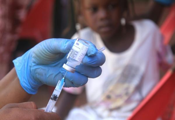 Un enfant soudanais observe la préparation d'un vaccin lors d'une campagne de vaccination contre la diphtérie dans un camp de déplacés dans la ville d'Al-Dabbah, dans le nord du Soudan, le 22 novembre 2025