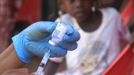 Un enfant soudanais observe la préparation d'un vaccin lors d'une campagne de vaccination contre la diphtérie dans un camp de déplacés dans la ville d'Al-Dabbah, dans le nord du Soudan, le 22 novembre 2025