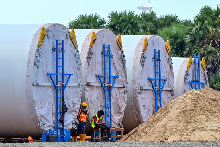 Cette photographie, prise le 2 octobre 2026, montre des mâts d'éoliennes en cours de préparation dans le cadre d'un projet éolien sur la péninsule de Mannar, au Sri Lanka