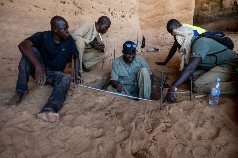Djimet Guemona, archéologue, au centre sur l'image, lors de fouilles à Garoa Hallagana, dans l'Ennedi-Ouest, au Tchad, le 10 juillet 2025