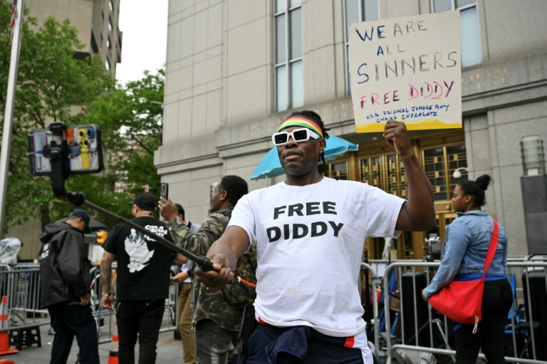 Un fan de P. Diddy brandit une pancarte à l'extérieur de la cour où il est jugé à New York, le 15 mai 2025.