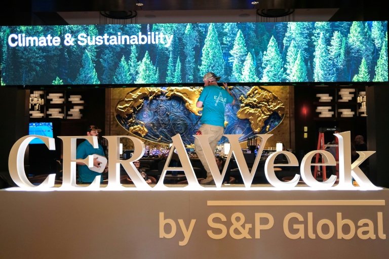 Deux hommes travaillent pour préparer le plus grand rendez-vous mondial des acteurs du pétrole, le 22 mars 2026 à Houston, au Texas