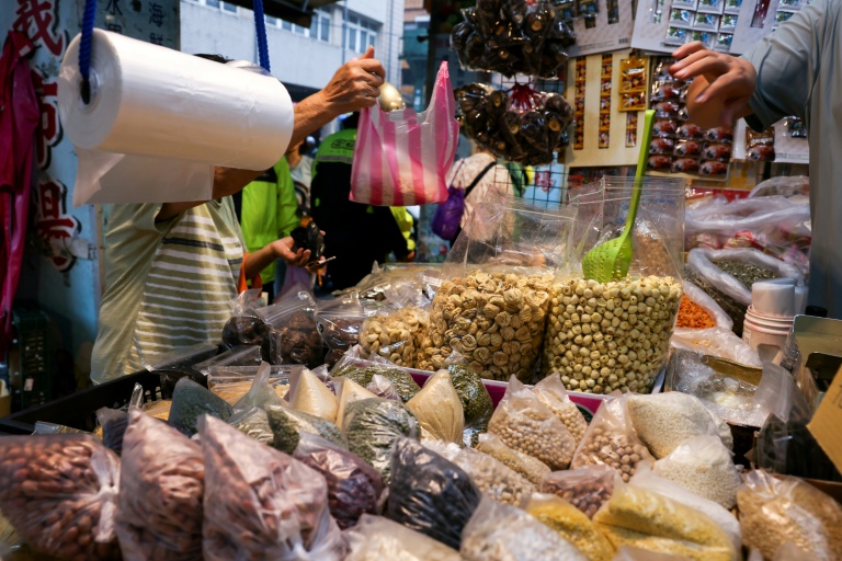 Un commerçant met des produits dans un sac en plastique sur un marché traditionnel de Keelung, à Taïwan, le 9 juin 2026
