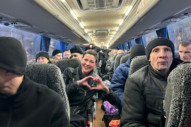 Photo handout diffusée le 13 décembre 2025, représentant l'opposante bélarusse Maria Kolesnikova, faisant un coeur avec ses doigts, dans un bus avec d'autres anciens prisonniers libérés.