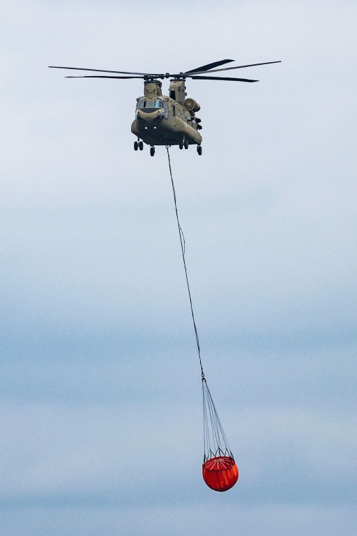 Un hélicoptère Chinook transporte une cargaison d'eau lors des opérations contre les incendies de forêt dans la réserve naturelle des Hautes Fagnes, près de Spa, le 19 août 2026