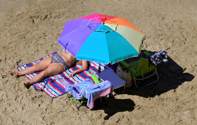 Une femme prend un bain de soleil sur une plage de Benidorm, en Espagne, le 10 septembre 2025