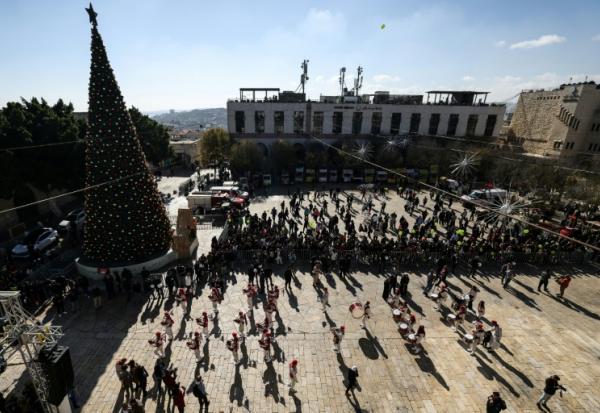 Une parade de scouts sur la place de la Mangeoire, devant la basilique de la Nativité à Bethléem, le 24 décembre 2025 en Cisjordanie occupée