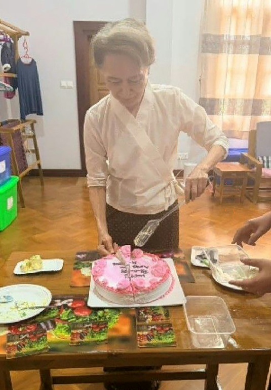 Cette photo d'archive non datée, diffusée le 3 août 2026 par le Bureau présidentiel de la presse et de l'information (PPIB) de Birmanie, montre l'ancienne dirigeante et prix Nobel de la paix Aung San Suu Kyi, actuellement détenue en résidence surveillée, en train de couper un gâteau.
