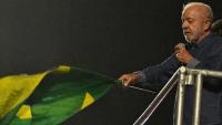 Le président de gauche Lula brandit un drapeau lors d'un discours de victoire au second tour de la présidentielle devant ses partisans à Sao Paulo, dans le sud-est du Brésil, le 25 octobre 2026