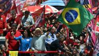 Le président brésilien de gauche Luiz Inacio Lula da Silva (C) agite le drapeau national lors d'un meeting de campagne à la veille du premier tour de la présidentielle, le 3 octobre 2026 à Sao Paulo