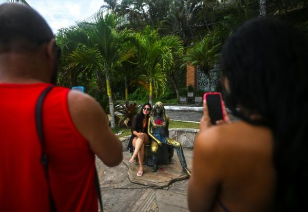 Une touriste pose à côté de la statue de Brigitte Bardot, à Buzios, au Brésil, le 3 janvier 2026