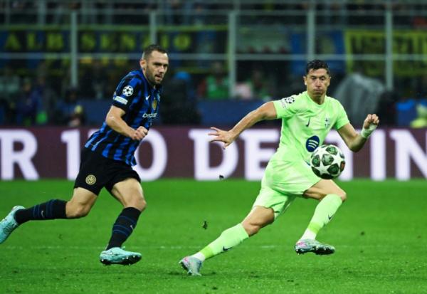 Le défenseur de l'Inter Milan Stefan de Vrij et l'attaquant barcelonais Robert Lewandowski (d) à la lutte lors de la demi-finale retour de Ligue des champions, le 6 mai 2025 à Milan