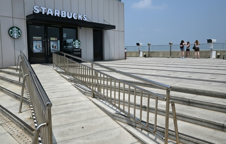 Des touristes observent la Corée du Nord depuis un point de vue à proximité d'un Starbucks située à l'Écoparc de la Paix d'Aegibong, à Gimpo, en Corée du Sud, le 1er juillet 2026 
