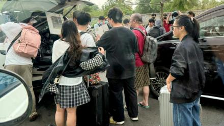 Des personnes chargent leurs bagages dans des véhicules après avoir quitté un complexe soupçonné d'être un centre d'escroquerie à Sihanoukville, le 15 janvier 2026 au Cambodge