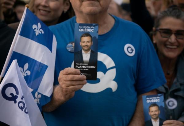 Un sympathisant tient un tract à l'effigie du chef du Parti québécois (PQ), Paul St-Pierre Plamondon, devant la Maison de Radio-Canada à Montréal, dans la province de Québec au Canada, le 23 septembre 2026