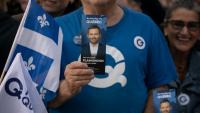 Un sympathisant tient un tract à l'effigie du chef du Parti québécois (PQ), Paul St-Pierre Plamondon, devant la Maison de Radio-Canada à Montréal, dans la province de Québec au Canada, le 23 septembre 2026