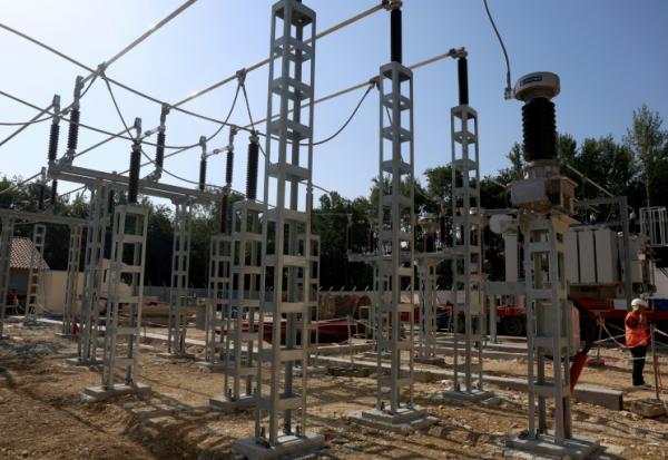 Salarié Enedis travaillant à l'installation d'un nouveau transformateur électrique à Pompignac, dans le département de la Gironde, le 1er juillet 2025. 