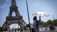 Une touriste se protège du soleil sous un parapluie, le 10 juillet 2026 à Paris 