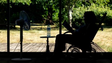 Une personne âgée assise face à un ventilateur à Pont-Audemer, dans l'Euroe, le 12 juillet 2026 lors d'une vague de chaleur en France