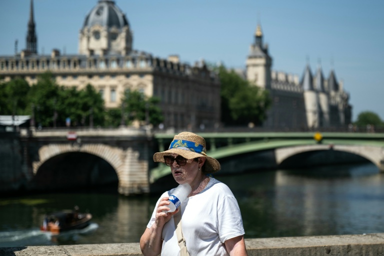 Une personne se rafraîchit avec une bouteille d'eau glacée, à Paris, le 21 juin 2026