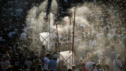 Des festivaliers se rafraichissent sous des jets d'eau mis en place pour lutter contre la canicule le 11 juillet 2026 au festival des Francofolies de La Rochelle en Charente-Maritime