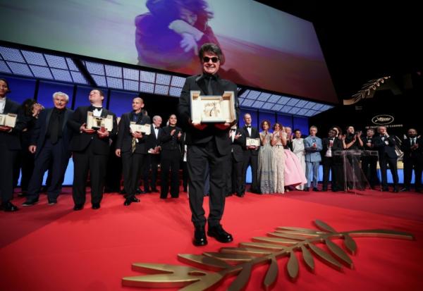 Le réalisateur iranien Jafar Panahi et sa Palme d'or pour le film "Un simple accident", lors de la cérémonie de clôture du 78e Festival de Cannes, le 24 mai 2025