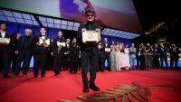Le réalisateur iranien Jafar Panahi et sa Palme d'or pour le film "Un simple accident", lors de la cérémonie de clôture du 78e Festival de Cannes, le 24 mai 2025